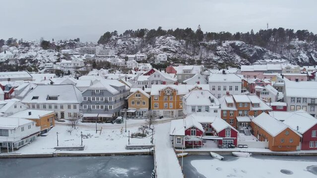 Snow covered Houses And Buildings In Kragero Town In Norway - aerial pullback