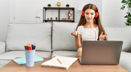 Adorable girl having online class sitting on sofa at home