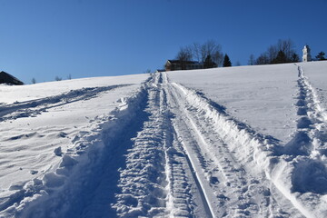 Fototapeta na wymiar A snowmobile trail under a blue sky, Sainte-Apolline, Québec, Canada