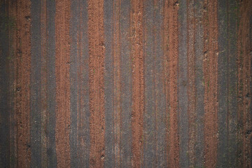 Italian arable land in winter season top view. Striped texture brown red color aerial view. Texture of arable land top view. Winter texture plowed land drone view.