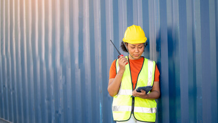 Woman foreman control loading Containers box in warehouse , Worker inspector or Safety Supervisor in Container CustomTerminal port concept import export transportation and logistic service