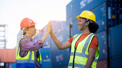Warehouse business. A Chinese man and a african american woman in safety suit high five hands and conclude a job for transport and logistics after  Successfully completed business Contract