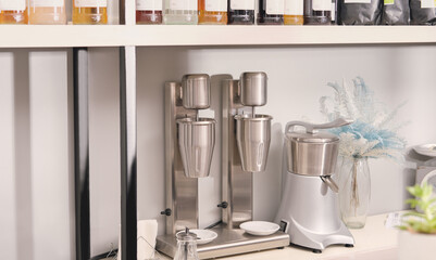 professional electric milk shaker for making two milkshakes standing on a bar counter. modern contemporary coffeeshop equipment.