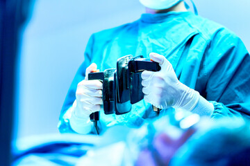 Doctor holding defibrillator paddles in both hands prepare help patient in operating room