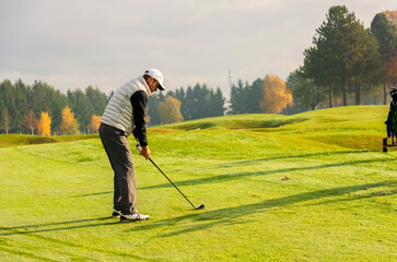 Fototapeta premium Golfer trying to make the perfect shot with a golf club