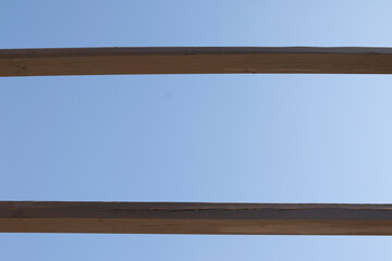 A wooden pergola with the sky in the background. Design concept.