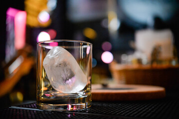glass whiskey glass with ice stands on the table

