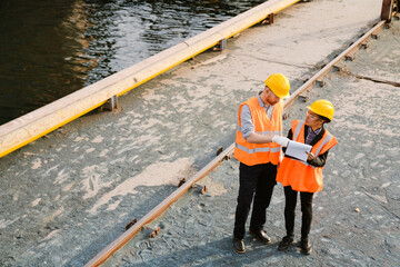 Multiracial man and woman working together at port
