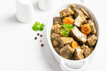 Chicken liver stir fry  in ceramic dish. Top view, copy space.