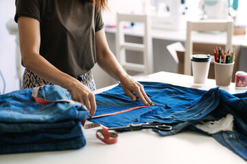 Mending Clothes, how to mend old Clothes. Sustainable fashion, Denim Upcycling Ideas, Using Old Jeans, Repurposing, Reusing Old Jeans, Upcycle Stuff. Woman seamstress cut and repair old blue jeans