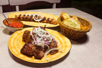 Appetizing, delicious kebab and shish kebab with chili tomato sauce