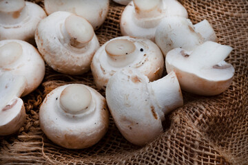 Raw White button mushrooms on rustic styled table surface