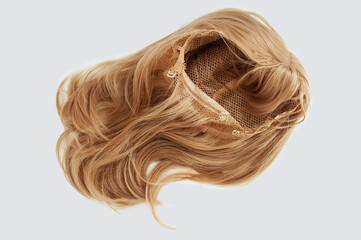 Naklejka premium Women wig with bangs on grid with fasteners blond. White background.