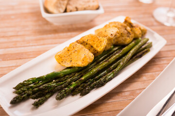 fried chicken breast pieces with asparagus on white plate