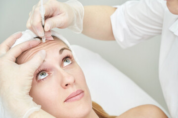 Injection at spa salon. Doctor hands in gloves. Closeup. Pretty female patient. Beauty treatment....