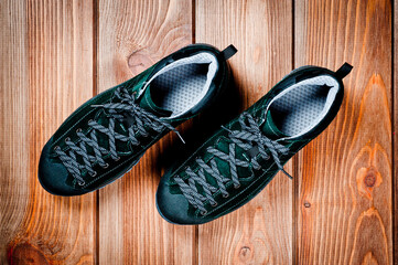 Dark green suede shoes laced with laces. Close-up shot.