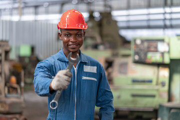 Portrait of engineer black worker wearing uniform safety with holding wrench tool stand in factory