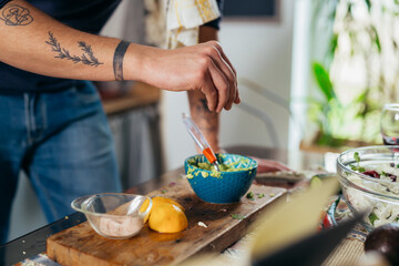 close up of man seasoning dressing for salad
