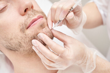 Injection at spa salon. Doctor hands in gloves. Closeup. Pretty male patient. Beauty treatment....