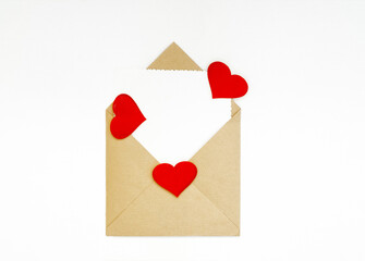 Kraft envelope with a white note sheet and red hearts on a white background. The concept of Valentine's day, love, anniversary. copy space