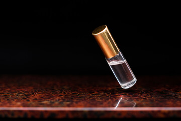luxury gold cap perfume bottle floating above a wooden table with dark background