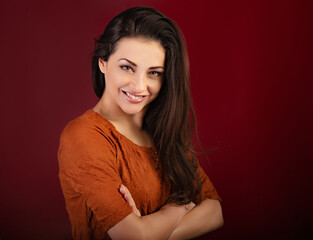 Naklejka premium Beautiful happy smiling woman on dark red background with empty copy space. Closeup front view portrait of natural female. Valentine's Day