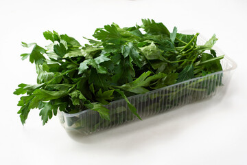 Fresh parsley in plastic packaging on a white background. Fresh herbs in a package