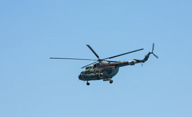 Fototapeta na wymiar The military helicopter against the blue sky