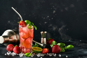 Punch cocktail. Two glasses of punch and fresh ingredients for making lemonade, infused detox water or cocktail. Strawberries, lime, mint, basil, ice cubes and shaker on black background. Top view.