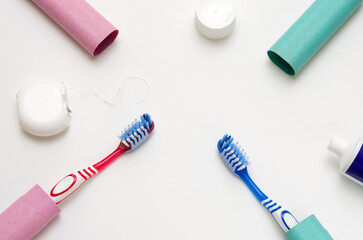 oral hygiene items toothbrushes, toothpaste, dental floss on white background