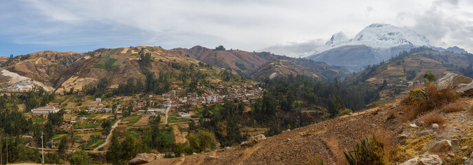 Panoramic image of a small rural town with the Huascaran mountain on the side, in Ancash, Peru