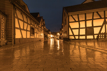 Gasse mit Fachwerkhäusern in der Nacht, nassgeregnet, im Regen
