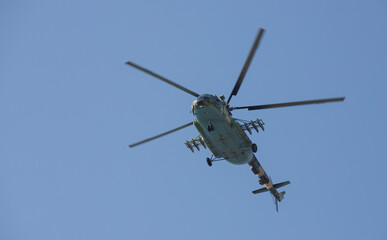 The military helicopter against the blue sky