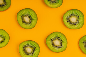 Fototapeta premium Kiwi sliced in a yellow background