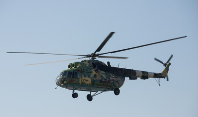 Fototapeta na wymiar The military helicopter against the blue sky