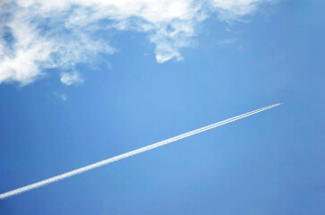 Small plane flying high in the blue sky. Bright blue sky background with free space for text.