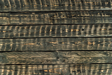 Texture of old shabby boards. Table with black erased paint. Background from old dark boards close-up. Brown wooden boards.