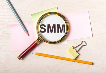 SMM social media marketing concept though magnifier.