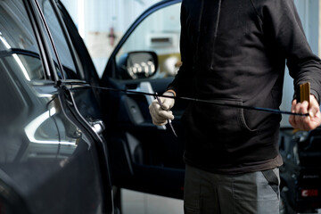 Close up of male car service worker applying nano coating on a car