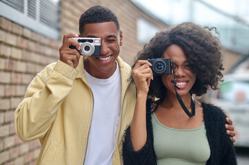 Man and woman looking through camera lens on street