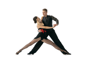 Dynamic portrait of flexible young dancers dancing Argentine tango isolated on white studio background. Artists in black stage costumes