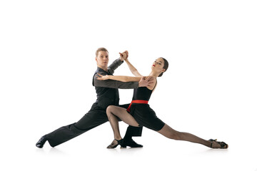 Obraz na płótnie Canvas Grace and beautiful dancers, young couple dancing Argentine tango isolated on white studio background. Artists in black stage costumes