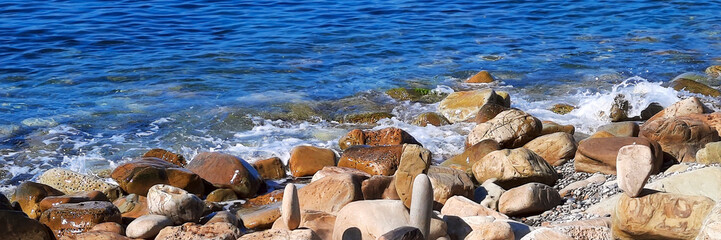 Coast with large stones in the sea water,soft focus. Panoramic natural background.