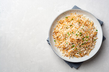 Rice with vermicelli in plate on concrete background. Traditional arabic dish.
