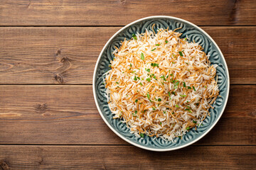 Rice with vermicelli in plate on wooden background. Traditional arabic dish.