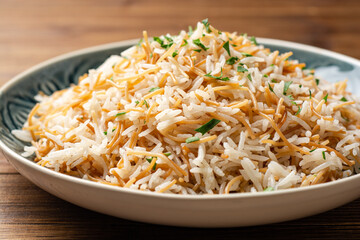 Rice with vermicelli in plate on wooden background. Traditional arabic dish.