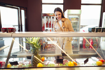 Female customer against raw meat stall section in food store