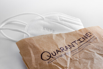 White generic KN95 (FFP2) facemask inside a brown paper bag with 