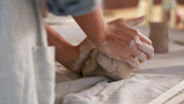 Woman potter knead clay at home