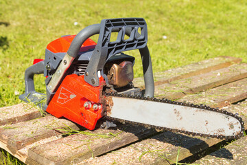 chainsaw in outdoors with green grass in background